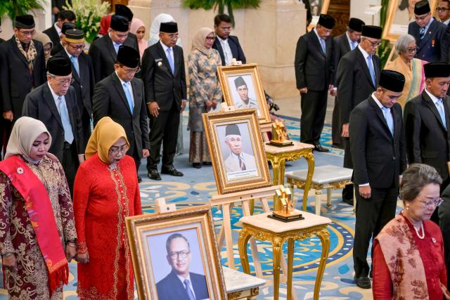 Family members and relatives observe a moment of silence during a ceremony held to mark the National Heroes Day at the State Palace in Jakarta on November 10, 2025. Indonesia added former president Suharto to a list of national heroes during a ceremony on November 10, despite objections from activists and academics over the deceased military dictator's human rights record. (Photo by BAY ISMOYO / AFP)