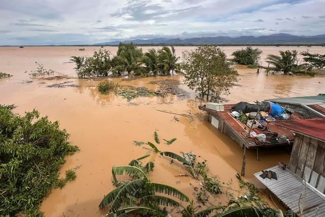 This photo shows a general view of flooded houses and rice fields in Ilagan City, Isabela province on November 10, 2025, after a river overflowed following heavy rains brought about by Super Typhoon Fung-wong. A weakening Typhoon Fung-wong departed the Philippines over the South China Sea on the morning of November 10, after its driving winds and heavy rain killed at least two people and forced more than a million to evacuate. (Photo by Villamor VISAYA / AFP)