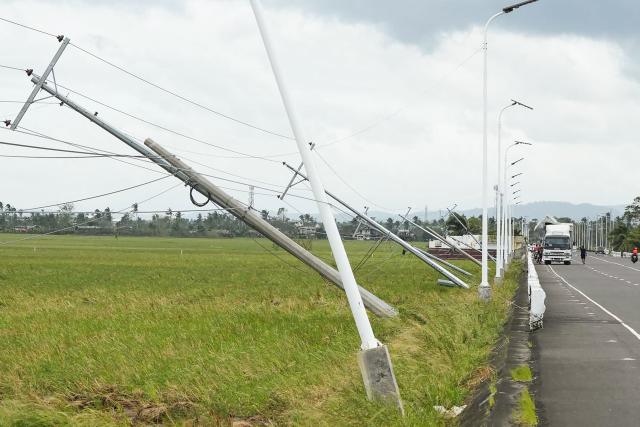 Electric posts toppled by strong wings brought about by Super Typhoon Fung-wong are seen in Tiwi town, Albay province, south of Manila on November 10, 2025. A weakening Typhoon Fung-wong departed the Philippines over the South China Sea on the morning of November 10, after its driving winds and heavy rain killed at least two people and forced more than a million to evacuate. (Photo by Charism SAYAT / AFP)