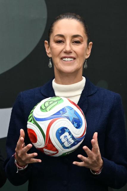 Mexican President Claudia Sheinbaum holds a FIFA Wold Cup 2026 official ball during a FIFA World Cup 2026 organization plan presentation in Mexico City, on November 10, 2025. (Photo by CARL DE SOUZA / AFP)