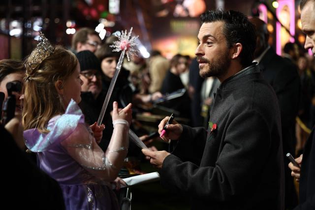 British actor Jonathan Bailey signs autographs for fans as he attends the European premiere of the film "Wicked: For Good" in central London on November 10, 2025. (Photo by HENRY NICHOLLS / AFP)