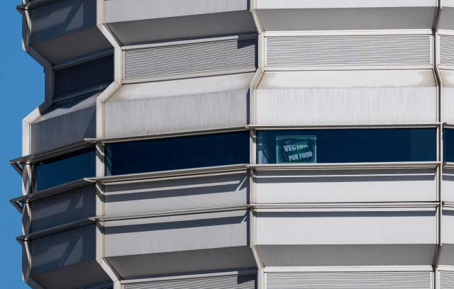 A sign displaying "Will Vector for Food" is displayed on the control tower at Ronald Reagan Washington National Airport in Arlington, Virginia on November 10, 2025. The US Senate took a major step on November 9 toward ending the longest government shutdown in American history when it cleared the way for a formal debate on a motion to resume funding to federal agencies. The deal between Democratic and Republican senators, just the first step to halting the shutdown, came as authorities warned US air travel could soon "slow to a trickle" as thousands more flights were cancelled or delayed over the weekend. (Photo by Andrew CABALLERO-REYNOLDS / AFP)