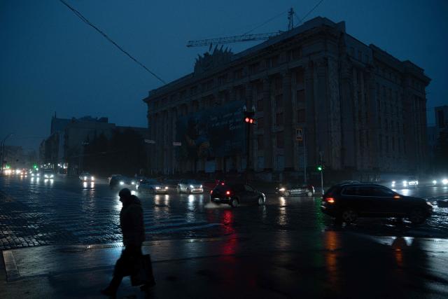 A pedestrian walks down a street without lighting in Kharkiv on November 10, 2025, following recent Russian missile and drone attacks on Ukrainian energy infrastructure, amid the Russian invasion of Ukraine. Russia has targeted the power and heating grid throughout its almost four-year invasion, destroying a large part of the key civilian infrastructure. (Photo by Ivan SAMOILOV / AFP)