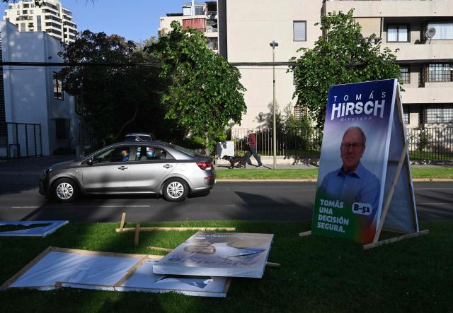 A car drives past electoral advertising posters in Santiago on November 10, 2025. Chile will hold presidential election on November 16. (Photo by RODRIGO ARANGUA / AFP)
