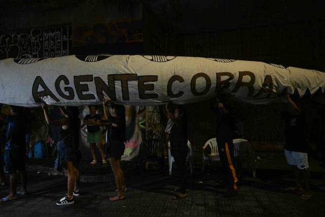 Activists prepare to march carrying a snake-shaped puppet in Belem, Brazil, on November 10, 2025, during a protest organized by Oxfam Brazil and the Alliance of Peoples for Climate to mark the end of the first day of COP30. The COP30 runs from November 10 to 21, and the 50,000 participants will feel the heavy, humid air of the Amazon rainforest, and face the daunting task of keeping global climate cooperation from collapsing. (Photo by Mauro PIMENTEL / AFP)