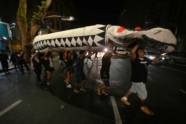 Activists march down a street carrying a snake-shaped puppet in Belem, Brazil, on November 10, 2025, during a protest organized by Oxfam Brazil and the Alliance of Peoples for Climate to mark the end of the first day of COP30. The COP30 runs from November 10 to 21, and the 50,000 participants will feel the heavy, humid air of the Amazon rainforest, and face the daunting task of keeping global climate cooperation from collapsing. (Photo by Mauro PIMENTEL / AFP)