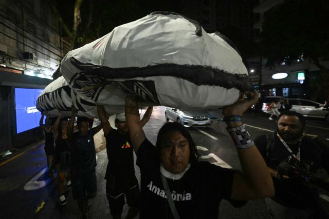 Activists march down a street carrying a snake-shaped puppet in Belem, Brazil, on November 10, 2025, during a protest organized by Oxfam Brazil and the Alliance of Peoples for Climate to mark the end of the first day of COP30. The COP30 runs from November 10 to 21, and the 50,000 participants will feel the heavy, humid air of the Amazon rainforest, and face the daunting task of keeping global climate cooperation from collapsing. (Photo by Mauro PIMENTEL / AFP)