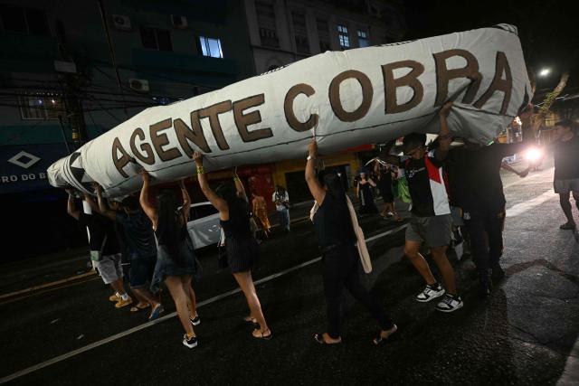 Activists march down a street carrying a snake-shaped puppet in Belem, Brazil, on November 10, 2025, during a protest organized by Oxfam Brazil and the Alliance of Peoples for Climate to mark the end of the first day of COP30. The COP30 runs from November 10 to 21, and the 50,000 participants will feel the heavy, humid air of the Amazon rainforest, and face the daunting task of keeping global climate cooperation from collapsing. (Photo by Mauro PIMENTEL / AFP)