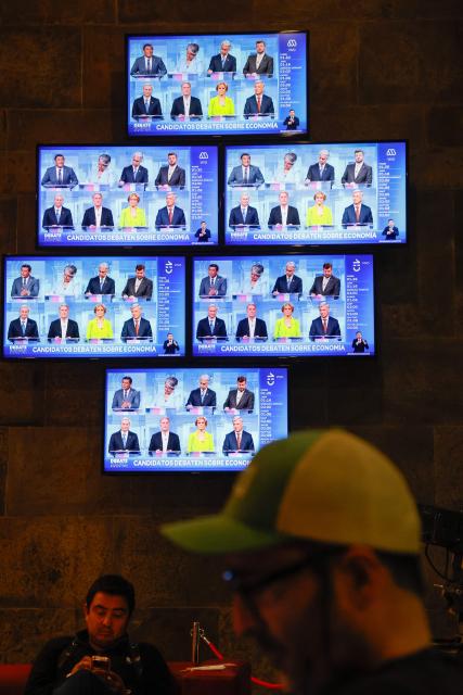 Chile's Presidential candidates are projected on TV screens during a presidential debate at TVN national channel in Santiago on November 10, 2025. Chile will hold presidential election on November 16. (Photo by Raul BRAVO / AFP)
