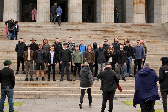 Members of the neo-Nazi National Socialist Network (NSN) pose for a photo after they unfurled a flag following a Remembrance Day service at Melbourne's Shrine of Remembrance on November 11, 2025. Each year on November 11 Australians mark Remembrance Day during which they observe a one minute's silence on the 11th hour of the 11th day of the 11th month to honour all who have served, suffered, or died in wars, conflicts, and peacekeeping operations. (Photo by William WEST / AFP)