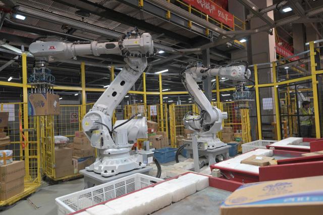 Robots sort packages at JD's warehouse during the double 11 festival or Singles's Day, China's massive annual shopping event in Beijing on November 11, 2025. (Photo by Adek BERRY / AFP)