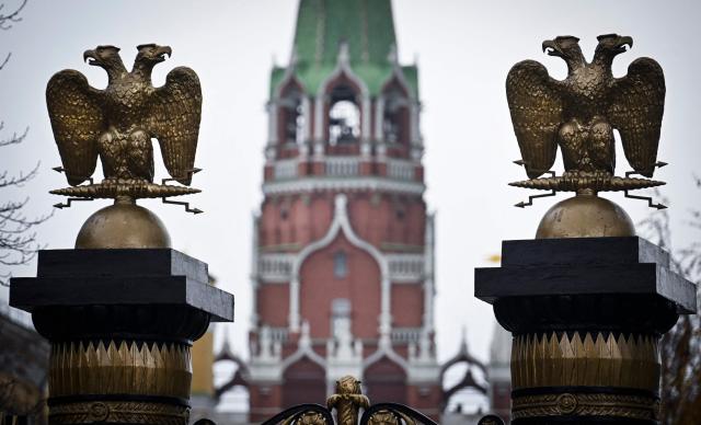 This photograph taken on November 11, 2025, shows statues of the double-headed eagles on the columns of the Alexandrovsky (Alexander's) Garden gate and the Troitskaya Tower of the Kremlin in Moscow. (Photo by Alexander NEMENOV / AFP)