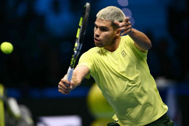 Spain's Carlos Alcaraz plays a backhand return to USA's Taylor Fritz during the ATP Finals tennis tournament in Turin on November 11, 2025. (Photo by Marco BERTORELLO / AFP)