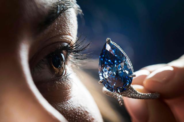 (FILES) A staff member shows a 9.51-carat vivid blue diamond, known as "The Mellon Blue", during its presentation at Christie’s auction house in Geneva on November 7, 2025. The "Mellon Blue", a 9.51-carat fancy vivid blue diamond formerly owned by the US art collector Bunny Mellon, sold for $25.6 million at auction on November 11, 2025, by auctioneers Christie's in Geneva as part of its Magnificent Jewels sale in the Swiss city. (Photo by Valentin Flauraud / AFP)