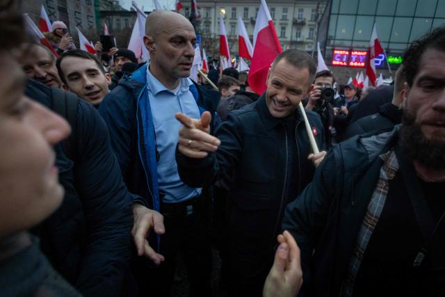 Poland's President Karol Nawrocki (C) greets other participants in the Poland's Independence Day march origanized by nationalist groups in Warsaw, Poland on November 11, 2025. (Photo by Wojtek RADWANSKI / AFP)