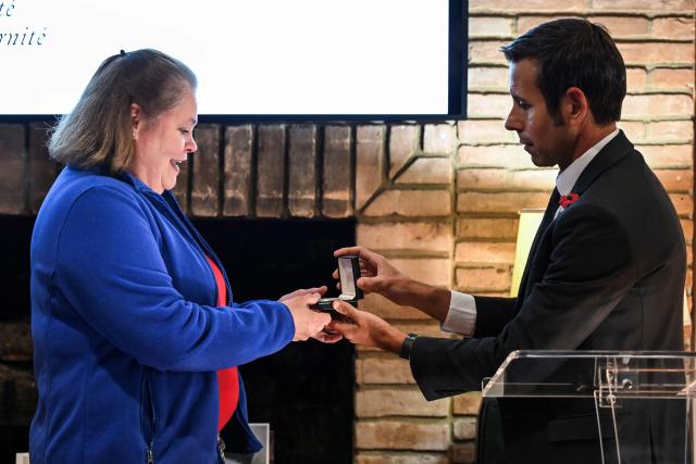 Joan Sheehan (L), daughter of John Joseph Sheehan, receives a lost US Navy bracelet found in France almost 80 years ago, from the Consul General of France Frank Marchetti at the Residence of France in Houston, Texas, on November 11, 2025. This bracelet -engraved with the name of its owner, sailor John Joseph Sheehan, his service number, blood type, and the affectionate inscription “Your wife Helen 1945”- was returned to the soldierґs daughter, Joan Sheehan, by the Consul General of France, Frank Marchetti. The bracelet was discovered in 1946 in Le Havre by Henriette Blanc, a local resident, who could not identify the owner despite several attempts, and kept the bracelet safely for decades in the hope of returning it to its rightful owner, a wish that was honored by her family and by French and American authorities, once she passed away. (Photo by RONALDO SCHEMIDT / AFP)