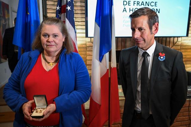 Joan Sheehan (L), daughter of John Joseph Sheehan, receives a lost US Navy bracelet found in France almost 80 years ago, from the Consul General of France Frank Marchetti at the Residence of France in Houston, Texas, on November 11, 2025. This bracelet -engraved with the name of its owner, sailor John Joseph Sheehan, his service number, blood type, and the affectionate inscription “Your wife Helen 1945”- was returned to the soldierґs daughter, Joan Sheehan, by the Consul General of France, Frank Marchetti. The bracelet was discovered in 1946 in Le Havre by Henriette Blanc, a local resident, who could not identify the owner despite several attempts, and kept the bracelet safely for decades in the hope of returning it to its rightful owner, a wish that was honored by her family and by French and American authorities, once she passed away. (Photo by RONALDO SCHEMIDT / AFP)