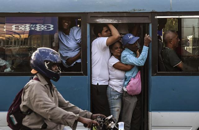 People travel on a crowded bus during a nationwide blackout in Santo Domingo on November 11, 2025. Santa Domingo found itself without electricity Tuesday as the Dominican Republic's energy company announced a blackout of unspecified scope, caused by a "transmission system failure." (Photo by Eddy Vittini / AFP)