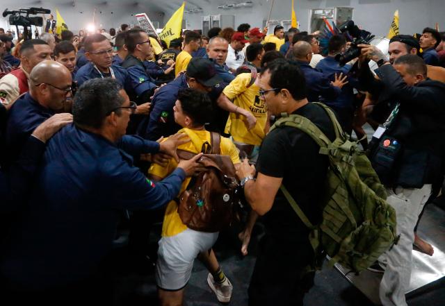Security personnel clash with indigenous people and students as they storm the venue during the COP30 UN Climate Change Conference in Belem, Para State, Brazil, on November 11, 2025. Dozens of indigenous protesters clashed with security guards at the COP30 summit in Belem on Tuesday while trying to enter the site, a rare incident for a UN climate conference, AFP journalists observed. (Photo by Olga Leiria / AFP)