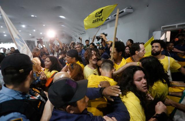 Security personnel clash with indigenous people and students as they storm the venue during the COP30 UN Climate Change Conference in Belem, Para State, Brazil, on November 11, 2025. Dozens of indigenous protesters clashed with security guards at the COP30 summit in Belem on Tuesday while trying to enter the site, a rare incident for a UN climate conference, AFP journalists observed. (Photo by Olga Leiria / AFP)