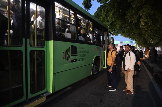 People travel by bus during a nationwide blackout in Santo Domingo on November 11, 2025. Santa Domingo found itself without electricity Tuesday as the Dominican Republic's energy company announced a blackout of unspecified scope, caused by a "transmission system failure." (Photo by Eddy Vittini / AFP)