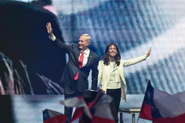 Chile's presidential candidate Jose Antonio Kast of the Republican Party and his wife  Maria Pia Adriasola greet supporters during his closing campaign rally at Movistar Arena in Santiago on November 11, 2025. Chile will hold the presidential election on November 16, 2025. (Photo by MARVIN RECINOS / AFP)