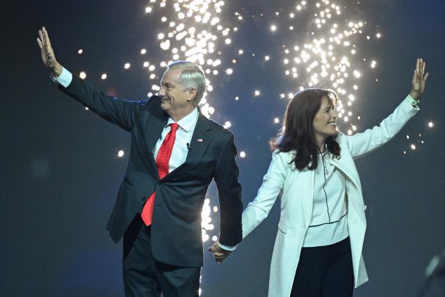 Chile's presidential candidate Jose Antonio Kast of the Republican Party and his wife  Maria Pia Adriasola greet supporters during his closing campaign rally at Movistar Arena in Santiago on November 11, 2025. Chile will hold the presidential election on November 16, 2025. (Photo by MARVIN RECINOS / AFP)