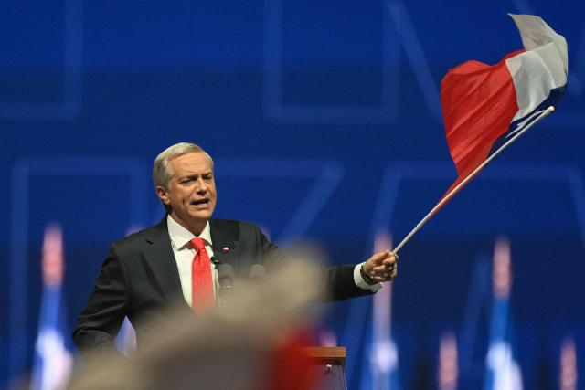 Chile's presidential candidate Jose Antonio Kast of the Republican Party waves a national flag during his closing campaign rally at Movistar Arena in Santiago on November 11, 2025. Chile will hold the presidential election on November 16, 2025. (Photo by MARVIN RECINOS / AFP)