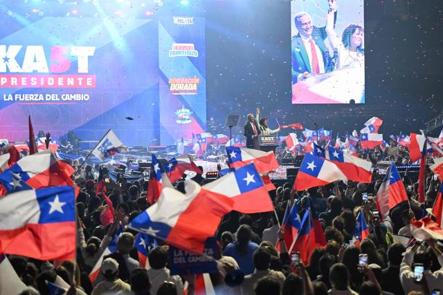 Chile's presidential candidate Jose Antonio Kast of the Republican Party and his wife Maria Pia Adriasola greet supporters during his closing campaign rally at Movistar Arena in Santiago on November 11, 2025. Chile will hold the presidential election on November 16, 2025. (Photo by Marvin RECINOS / AFP)