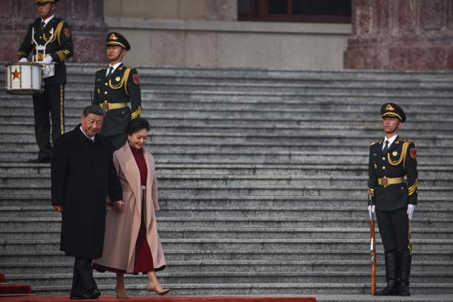 China's President Xi Jinping (L) and his wife Peng Liyuan (2nd L) walk during a welcoming ceremony for Spain's King Felipe VI at the Great Hall of the People in Beijing on November 12, 2025. (Photo by ANDRES MARTINEZ CASARES / POOL / AFP)