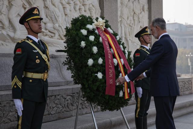 Spain's King Felipe VI (R) attends a flower wreath ceremony at the Monument to the People's Heroes, in Tiananmen Square, in Beijing on November 12, 2025. (Photo by ANDRES MARTINEZ CASARES / EPA-POOL / AFP)