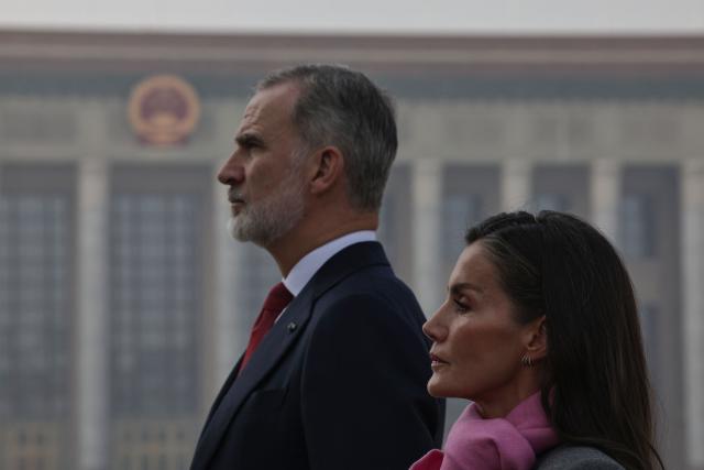 Spain's King Felipe VI and Queen Letizia walk following members of the honour guard during a flower wreath ceremony at the Monument to the People's Heroes, in Square, in Beijing on November 12, 2025. (Photo by ANDRES MARTINEZ CASARES / EPA-POOL / AFP)