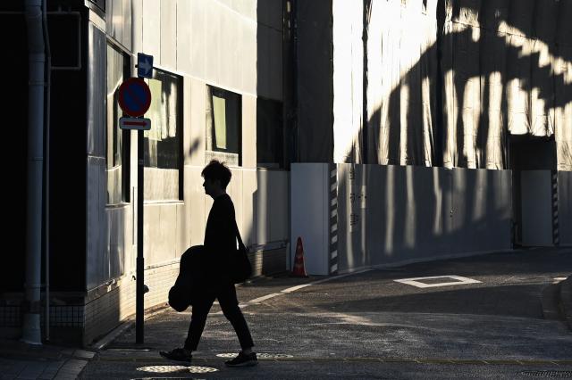 A man walks in a street in the Yurakucho area of Tokyo on November 12, 2025. (Photo by GREG BAKER / AFP)