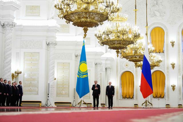 Russia's President Vladimir Putin and Kazakhstan's President Kassym-Jomart Tokayev listen to national anthems during their meeting at the St. George's Hall of the Grand Kremlin Palace in Moscow on November 12, 2025. (Photo by Alexander Zemlianichenko / POOL / AFP)