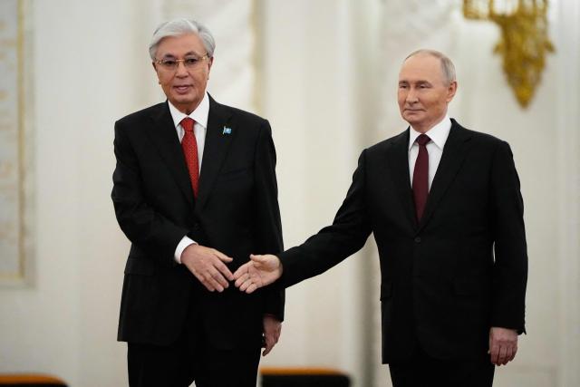 Russia's President Vladimir Putin and Kazakhstan's President Kassym-Jomart Tokayev shake hands during their meeting at the St. George's Hall of the Grand Kremlin Palace in Moscow on November 12, 2025. (Photo by Alexander Zemlianichenko / POOL / AFP)
