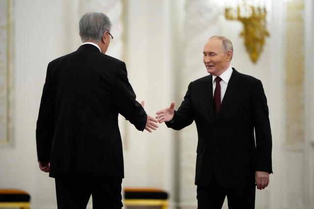 Russia's President Vladimir Putin and Kazakhstan's President Kassym-Jomart Tokayev shake hands during their meeting at the St. George's Hall of the Grand Kremlin Palace in Moscow on November 12, 2025. (Photo by Alexander Zemlianichenko / POOL / AFP)
