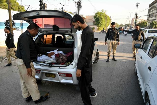 A policeman searches a vehicle along a road in Karachi on November 12, 2025, a day after a suicide bombing blast in Islamabad. Residents in Pakistan were facing tightened security checks on November 12 in the wake of a suicide bombing that left top officials vowing to halt the rise in deadly attacks. At least 12 people were killed and 27 wounded in the suicide bombing, the first such incident to hit the capital in nearly three years. (Photo by Asif HASSAN / AFP)