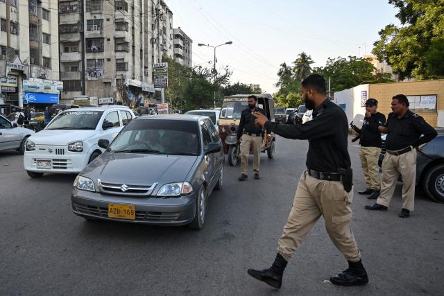 A policeman stops vehicles for searches along a road in Karachi on November 12, 2025, a day after a suicide bombing blast in Islamabad. Residents in Pakistan were facing tightened security checks on November 12 in the wake of a suicide bombing that left top officials vowing to halt the rise in deadly attacks. At least 12 people were killed and 27 wounded in the suicide bombing, the first such incident to hit the capital in nearly three years. (Photo by Asif HASSAN / AFP)