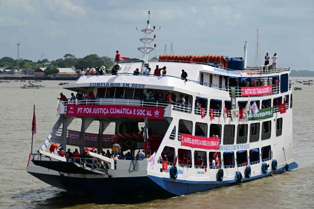 View of a boat taking part in a trip of indigenous people and social organizations in the sidelines of the COP30 UN Climate Change Conference in Belem, Para State, Brazil, on November 12, 2025. Over 150 boats with members of indigenous communities and social organizations will sail the Guama River as part of a symbolic crossing during the COP30, according to organizers. (Photo by Pablo PORCIUNCULA / AFP)