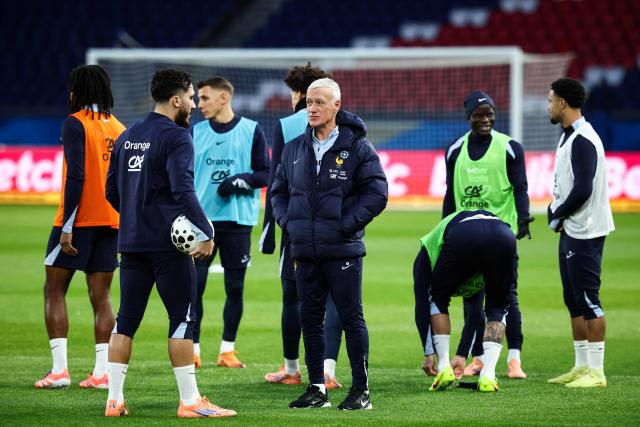 France's head coach Didier Deschamps (R) speaks with France's forward #19 Rayan Cherki (L) as he leads a training session at the Parc des Princes stadium, in Paris, on November 12, 2025 on the eve of the FIFA World Cup 2026 Group D European qualification football match against Ukraine. (Photo by FRANCK FIFE / AFP)