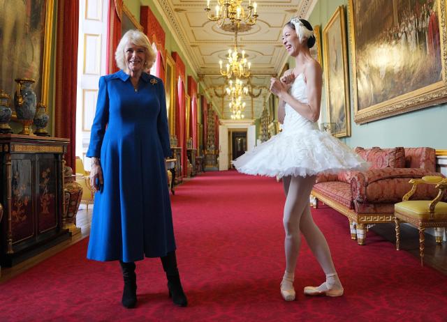Britain's Queen Camilla reacts alongside South Korean ballerina Sangeun Lee, during a reception to celebrate the English National Ballet's 75th anniversary, at Buckingham Palace in central London on November 12, 2025. (Photo by Yui Mok / POOL / AFP)