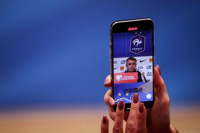 A journalist films with a mobile phone Ukraine's coach Serguey Rebrov speaking during a press conference at the Parc des Princes stadium, in Paris, on November 12, 2025 on the eve of the FIFA World Cup 2026 Group D European qualification football match against France. (Photo by FRANCK FIFE / AFP)