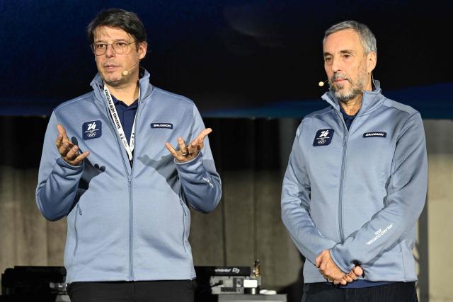 Ceo and President of Salomon, Guillaume Meyzenq (L) and Ceo of Milano Cortina 2026, Andrea Varnier speak during a press presentation of the official Milano Cortina 2026 volunteer uniforms, in Milan on November 12, 2025. (Photo by PIERO CRUCIATTI / AFP)