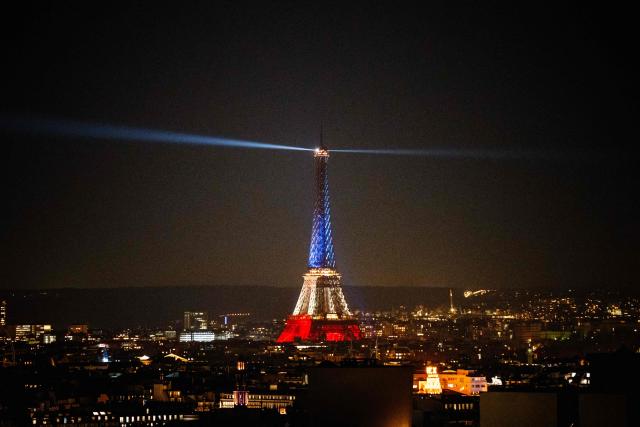 This photograph shows the Eiffel Tower illuminated in the colours of the French national flag to commemorate the 10th Anniversary of the 2015 Paris terror attacks, in Paris, on November 12, 2025. France marks a decade since suffering its worst attack on Paris since World War II, when Jihadist gunmen and suicide bombers staged a series of coordinated attacks in and around Paris on the night of November 13, 2015, killing 130 people, with the Islamic State group claiming responsibility. (Photo by Dimitar DILKOFF / AFP)