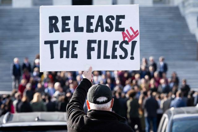 A protester holds a sign related to the release of the Jeffrey Epstein case files outside the US Capitol in Washington, DC, November 12, 2025. Democrats released emails Wednesday in which Jeffrey Epstein suggested Donald Trump was aware of the disgraced financier's sexual abuse and had "spent hours" with one of his victims at his house. Trump has denied any knowledge of the sex-trafficking activities of his former friend, who died by suicide in 2019 as he was in prison awaiting trial, and the White House accused Democrats of pushing a "fake narrative" by sharing the mails. (Photo by SAUL LOEB / AFP)
