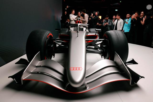 Massimo Frascella (C), Chief Creative Officer at AUDI AG, together with Kick Sauber's German driver Nico Hulkenberg (L) and Kick Sauber's Brazilian driver Gabriel Bortoleto (R) unveils the F1 car of the Audi F1 factory team set to compete in the Formula One starting in the 2026 season in Munich, southern Germany on November 12, 2025. (Photo by Alexandra BEIER / AFP)
