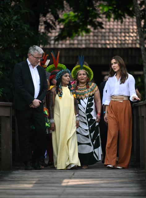 Denmark's Queen Mary (R) walks with local Indigenous leaders during her visit at Utinga Park in the sidelines of the COP30 UN Climate Change Conference in Belem, Para State, Brazil on November 12, 2025. (Photo by Mauro PIMENTEL / AFP)