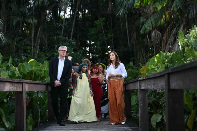 Denmark's Queen Mary (R) and Denmark's Minister of Food, Agriculture and Fisheries, Jacob Jansen (L) speak with local Indigenous leaders during their visit to Utinga Park in the sidelines of the COP30 UN Climate Change Conference in Belem, Para State, Brazil on November 12, 2025. (Photo by Mauro PIMENTEL / AFP)