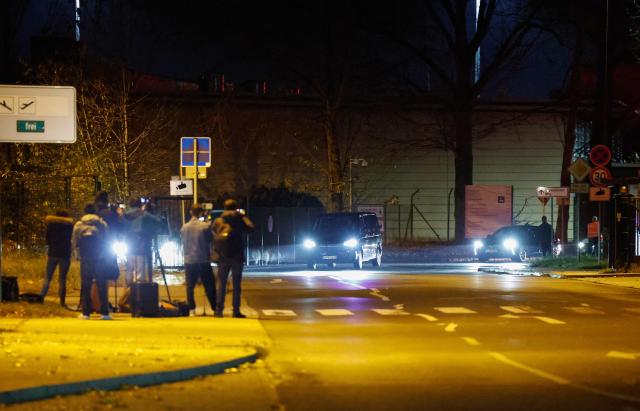 Members of the media film a convoy believed to be transporting Franco-Algerian writer Boualem Sansal as they leave Berlin's Schoenefeld airport on November 12, 2025 after Algeria has accepted a request by Germany's President to free the 81-year-old for medical treatment after a year in detention. Sansal was given a five-year jail term in March 2025, accused of undermining Algeria's territorial integrity after he told a far-right French outlet last year that France had unjustly transferred Moroccan territory to Algeria during the 1830 to 1962 colonial period. (Photo by Odd ANDERSEN / AFP)