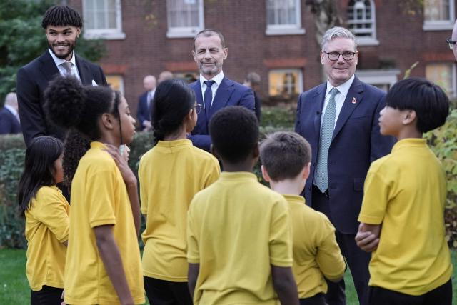 Britain's Prime Minister Keir Starmer (R), UEFA president Aleksander Ceferin (2nd L) and England football player Tyrone Mings (L) chat with children from "John Keble C of E" primary school at 10 Downing Street in London on November 12, 2025, during a visit by UEFA officials to mark the launch of UEFA Euro 2028. The UEFA Euro 2028 tournament is set to be jointly hosted by the United Kingdom and Ireland. (Photo by Stefan Rousseau / POOL / AFP)